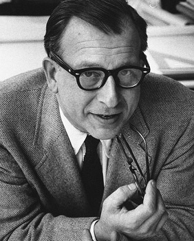 Eero Saarinen portrait en noir et blanc. Homme aux cheveux courts et avec des lunettes. Il tient une paire de lunettes dans sa main droite. Il porte une veste de costume et une cravatte.